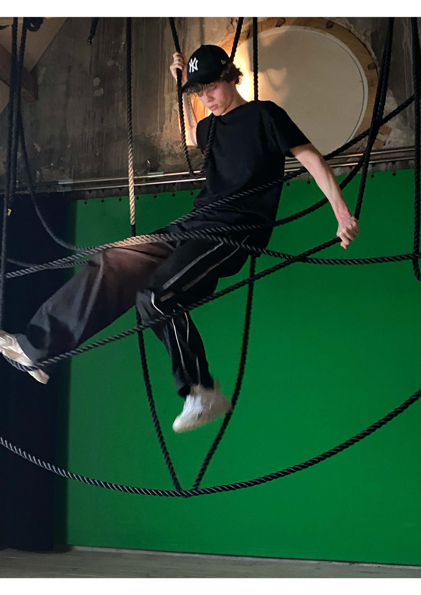 foto van een jongen in een constructie van touwen