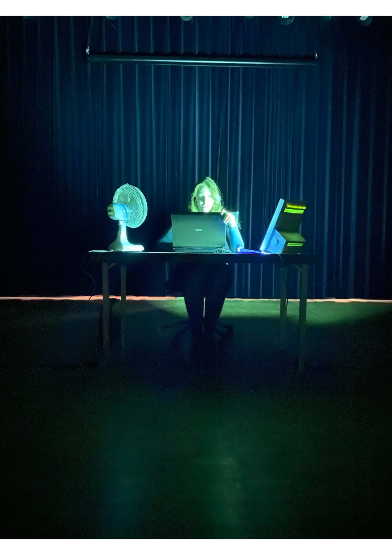 foto van een persoon achter een bureau met een laptop en een ventilator