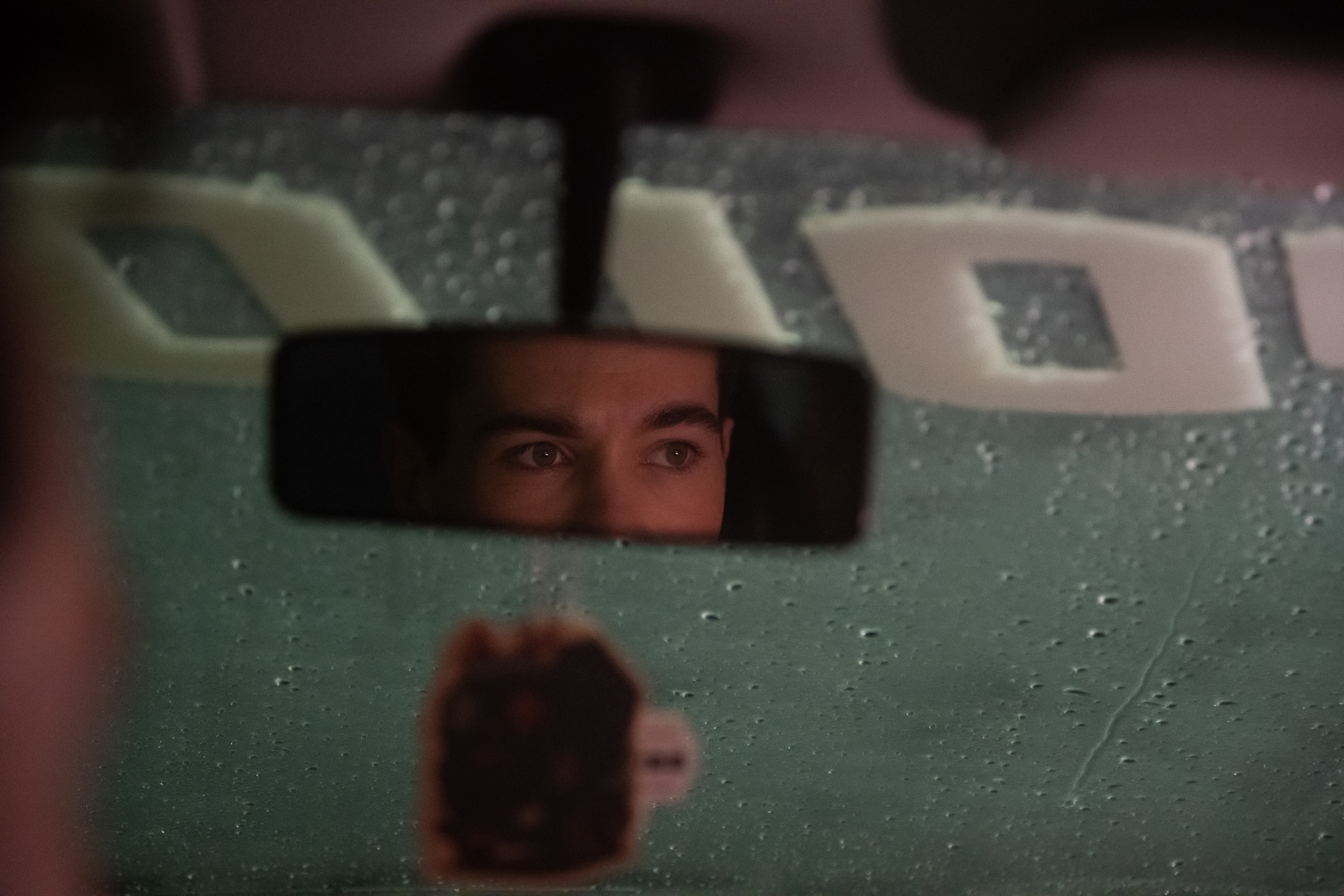 Foto van de achteruitkijkspiegel in de auto waar iemand in kijkt